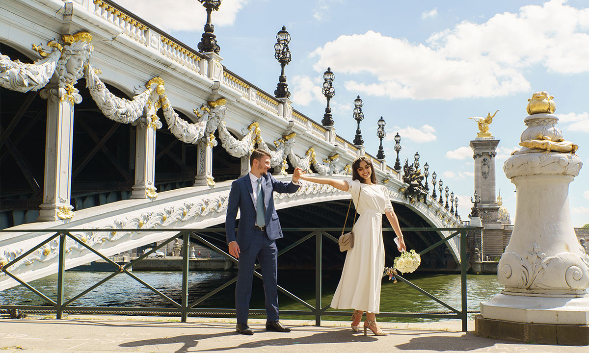 photo de mariage sous le pont alexandre 3 Paris. Le couple de mariés prend une pose photo en train de danser
