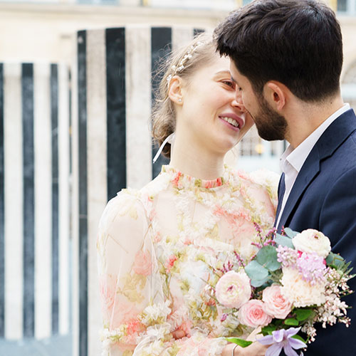 photo couple mariée blonde et marié brun s'embrassant au palais royal paris