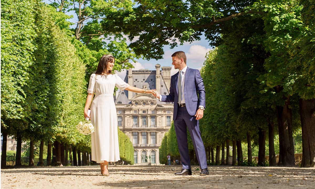 Photo de couple mariage aux Jardin des Tuileries, au Louvre, lieu iconique pour photos de mariage à Paris, lieu shooting couvert