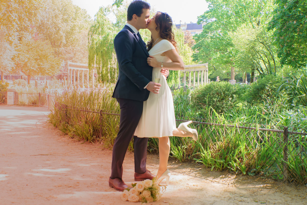Photo de couple mariage Paris au Parc Monceau, baiser romantique en pleine nature