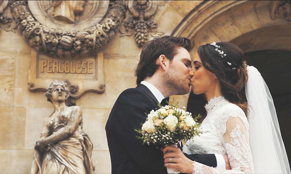 Photo de mariage chic d'un couple de mariés s'embrassant devant l'opéra garnier à Paris.