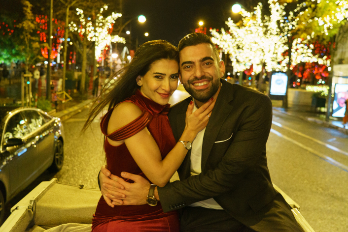 demande en mariage à Paris, couple heureux dans une calèche décapotée avenue Montaigne, avec décorations lumineuses des arbres à Noël