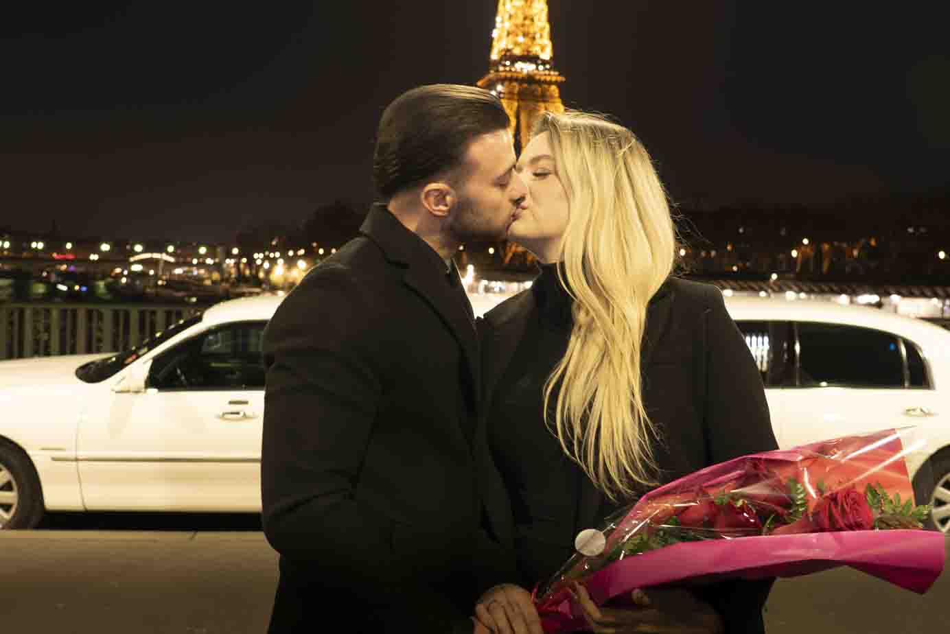 Séance photo demande en mariage à Paris : couple s'enlaçant devant la Tour Eiffel illuminée de nuit.