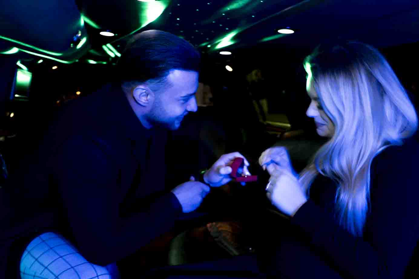 Photographe demande en mariage Paris : fiancée recevant sa bague de fiançailles dans une limousine.