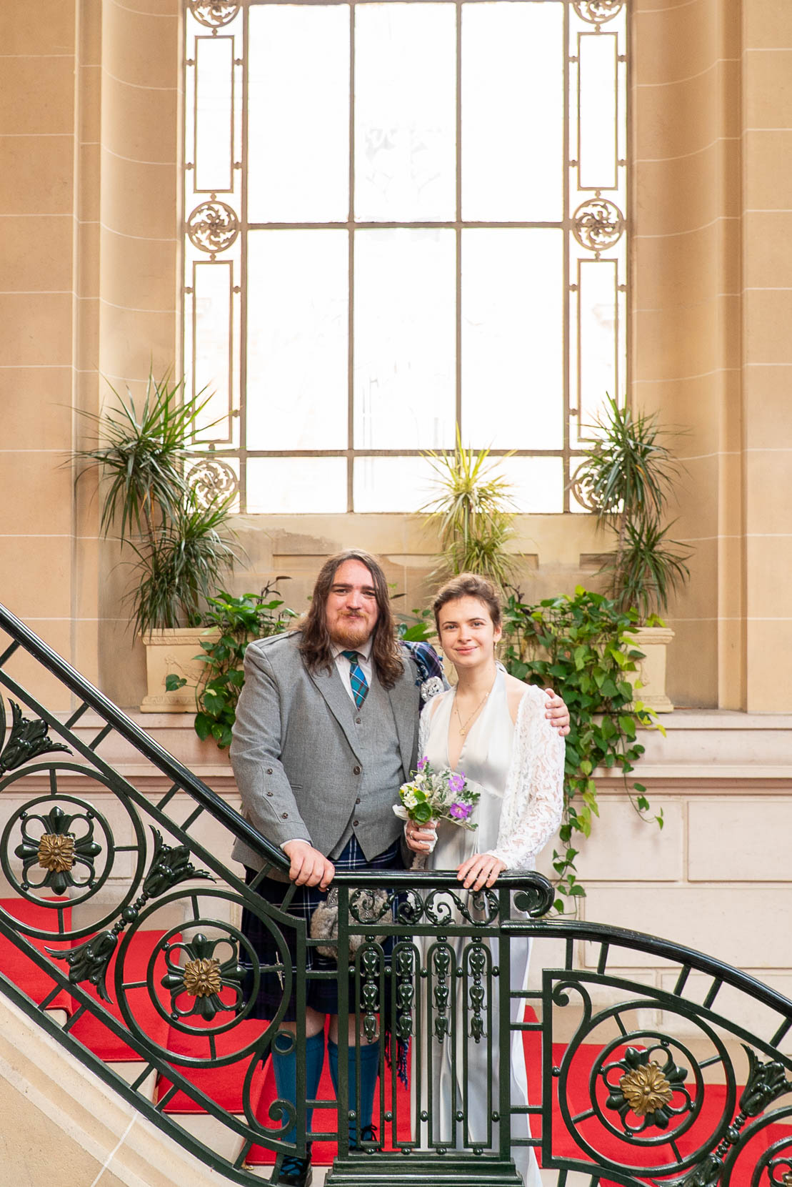 Portrait élégant et naturel des mariés dans les escaliers d'honneur de la mairie du 19e — photographe mariage Paris élégant